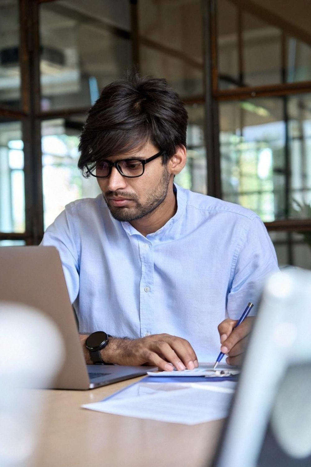 Young professional preparing for ACCA papers with laptop and written notes
