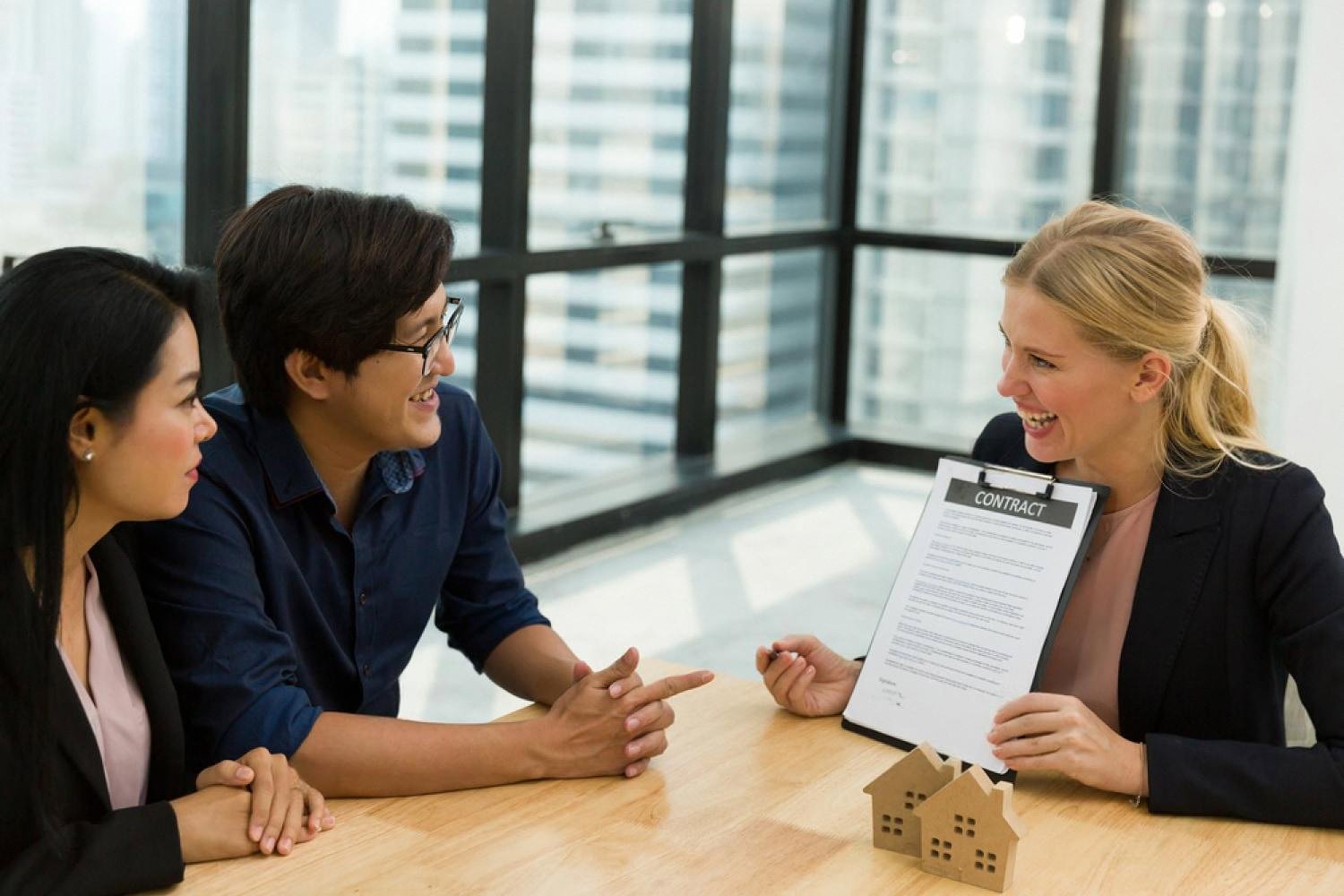 Insurance agent showing an apartment insurance contract to a couple in a Dubai office